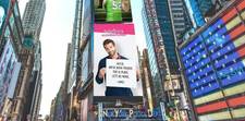 A big, bright Teleflora ad showing one man's confession of love. He is holding a sign that reads &quot;Alicia, we've been friends for 12 years. Let's be more.&quot; - James